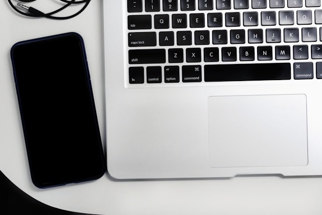 iPhone and MacBook sitting on a desk